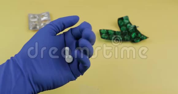 一个椭圆形和一个圆形的白色药片穿着蓝色的医用手套视频的预览图