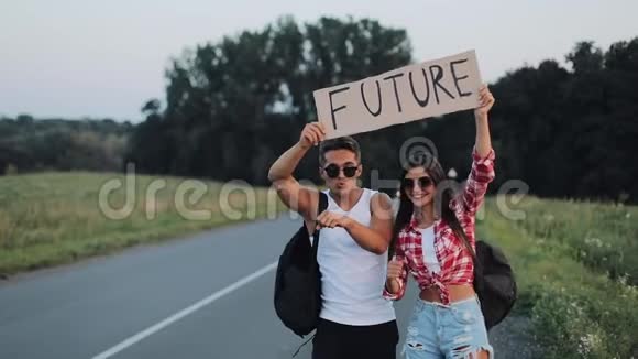 一对年轻夫妇正站在路上搭便车一男一女在高速公路上停车标志着未来视频的预览图