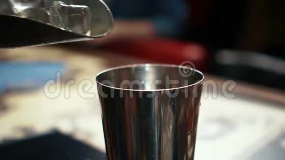 男酒保正在时髦的酒吧里往玻璃杯里放冰块视频的预览图