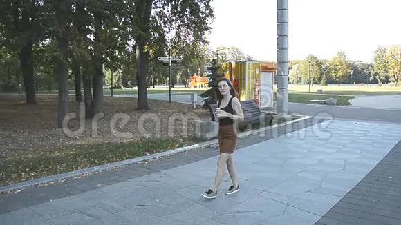 在城市公园散步吃冰淇淋的女人视频的预览图