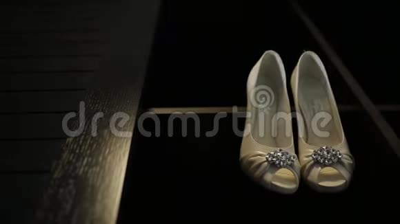 新娘婚礼漂亮的鞋子挂在一个黑色的柜子上豪华的鞋跟特写视频的预览图