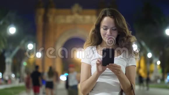 年轻女子在智能手机上对巴塞罗那的ArcdeTriomf发短信视频的预览图