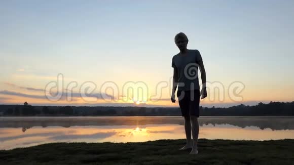 在斯洛莫日落时分金发男子从一个湖边跑到一个摄影师那里视频的预览图