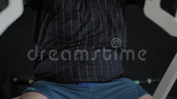 超重的成年男子在模拟器上训练他的胸部视频的预览图