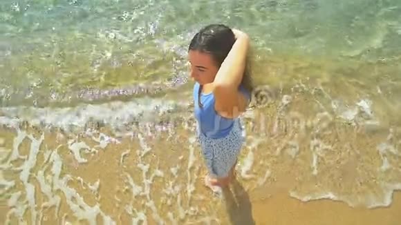 海滩上的女人景色阳光明媚的海滩和清澈的碧水慢动作视频的预览图