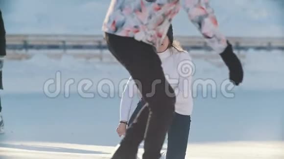 俄罗斯女孩滑冰在公共冰场上摔倒并站起来视频的预览图