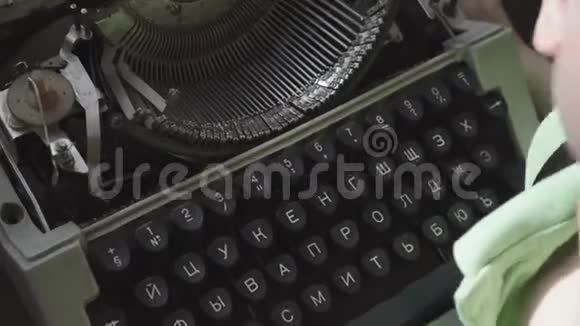 六岁的小男孩学习一台旧打字机的工作特写双手视频的预览图