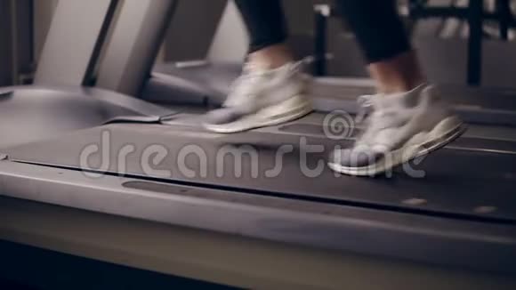 在跑步机上穿着漂亮运动鞋的女性腿的慢动作镜头视频的预览图