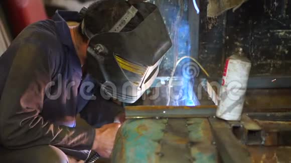 戴口罩的工人使用焊机视频的预览图