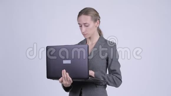 年轻的金发碧眼的女商人在用笔记本电脑思考视频的预览图