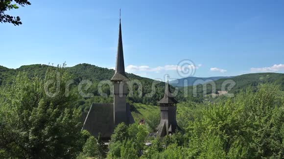 罗马尼亚比尔萨纳修道院绿色自然中的大塔木制教堂视频的预览图