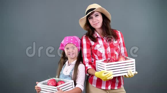 农民家庭的画像母亲和女儿手拿着装有红色成熟有机苹果的木箱视频的预览图