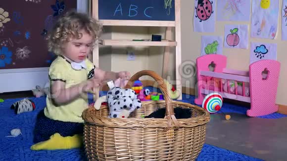 小女孩把玩具放在柳条篮子里家里凌乱的房间视频的预览图