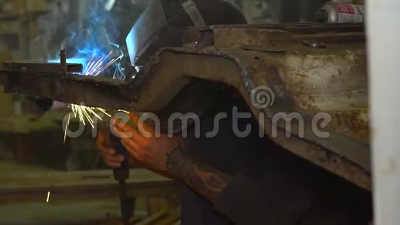 戴口罩的焊工修理汽车车身修理汽车车身视频的预览图