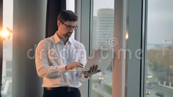 一个商人在笔记本电脑上以圆形的视角打字视频的预览图