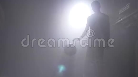 一个篮球运动员剪影在雾蒙蒙的黑暗房间里玩球里面有泛光灯视频的预览图