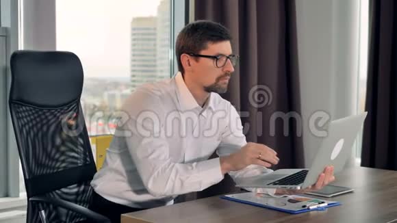 一个商人手里拿着笔记本电脑工作视频的预览图