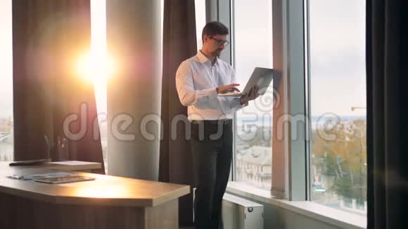 一个商人在现代办公室打字之间的距离很远视频的预览图