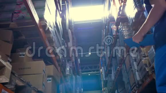 一个仓库工人抬头看着高高的天花板储存架视频的预览图