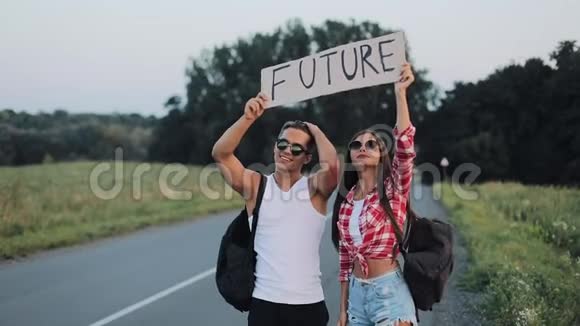 一对年轻夫妇正站在路上搭便车一男一女在高速公路上停车标志着未来视频的预览图
