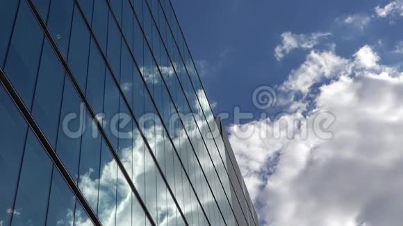 蓝天上飘逸的白云映着现代玻璃建筑视频的预览图