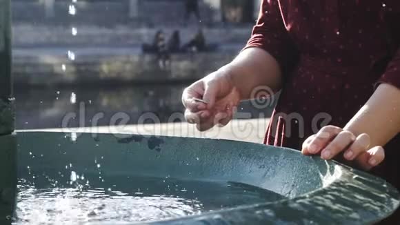 女游客往喷泉里扔硬币视频的预览图