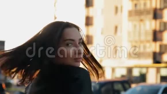 日落时一位年轻女子走在城市的街道上视频的预览图