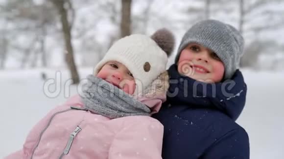 幸福的家庭在下雪的冬天滑雪父亲和母亲在下雪时带着儿子和女儿拉雪橇男孩和女孩视频的预览图