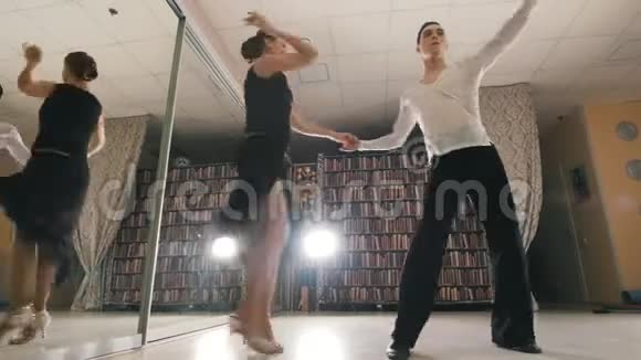 年轻迷人的男人和女人在工作室里穿着服装跳舞拉丁美洲舞蹈专注于脚从视野中看到视频的预览图