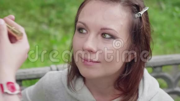 化妆师在女孩的脸上涂上增白剂并在拍照前调和肤色视频的预览图