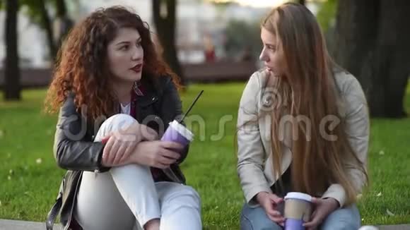 两个年轻漂亮的女人在户外聊天喝咖啡视频的预览图