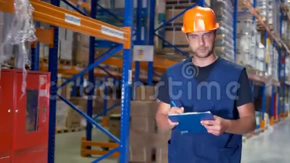 一个男性仓库检查员在转弯时做剪贴板笔记4K视频的预览图