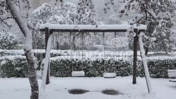 冬天公园里几只被雪覆盖的空秋千视频的预览图