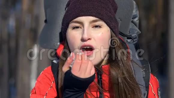 迷人的旅游女孩从她的手中吹下了雪视频的预览图