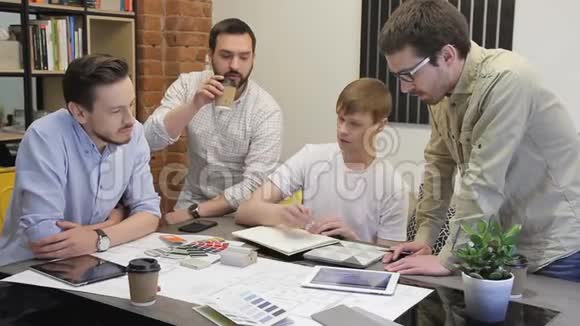 团队4人头脑风暴创意办公室年轻人围着桌子走过来视频的预览图