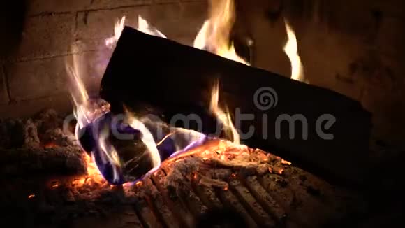 在黑暗中的传统壁炉中燃烧的木原木特写视频的预览图