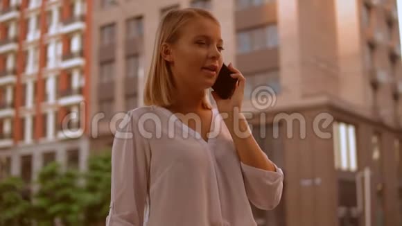 在城里用手机说话的白人金发女郎视频的预览图