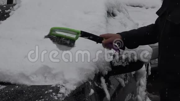 男人用手把车上的雪擦干净视频的预览图