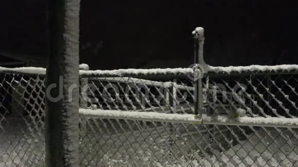 晚上在栅栏门上下雪视频的预览图