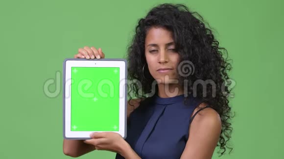 年轻漂亮的西班牙女商人展示数码平板电脑视频的预览图