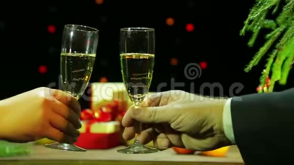 一男一女在庆祝圣诞节时手里拿着香槟杯一起撞着他们视频的预览图