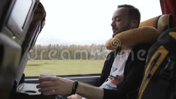 在春天的公共汽车旅行中没有胡子的人喝咖啡视频的预览图