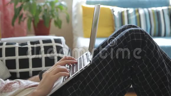 有笔记本电脑的年轻人坐在客厅的沙发上视频的预览图