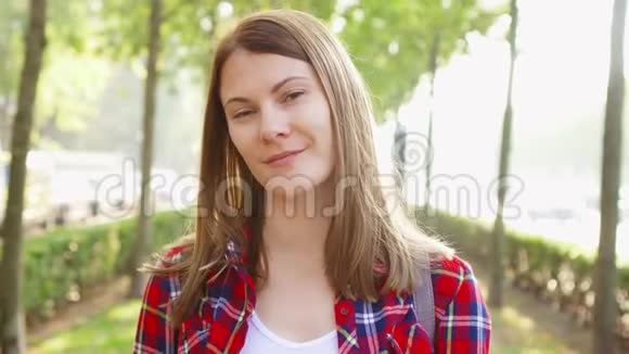 幸福快乐的年轻女人享受大自然的肖像站在公园里对着镜头微笑视频的预览图