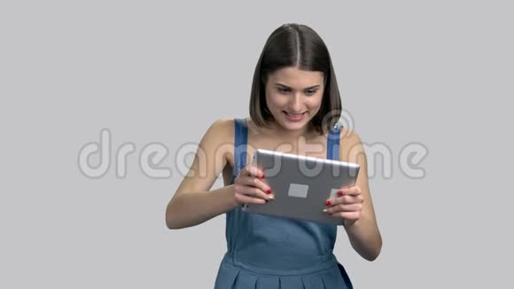快乐的女孩在电脑平板电脑上玩视频的预览图