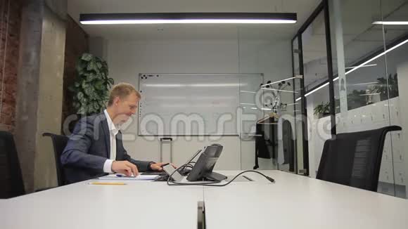 有经验的专家在电脑桌上工作并写作坐在公司里视频的预览图