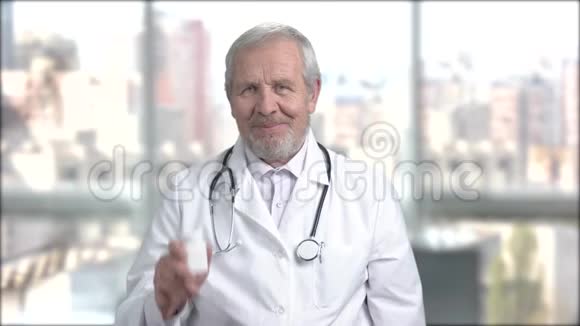 年长的微笑医生带着药丸展示瓶子视频的预览图