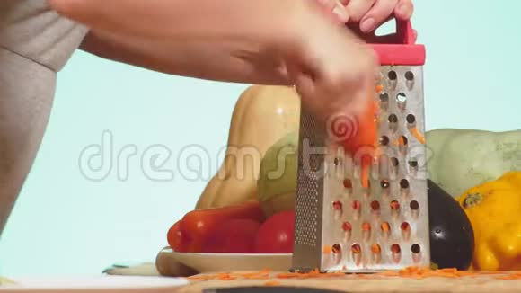 雌性的手擦在磨碎的胡萝卜上蔬菜混合物用于烹饪蔬菜炖背景色4k视频的预览图