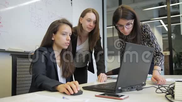 女员工一边说话一边看着大公司的PC屏幕视频的预览图