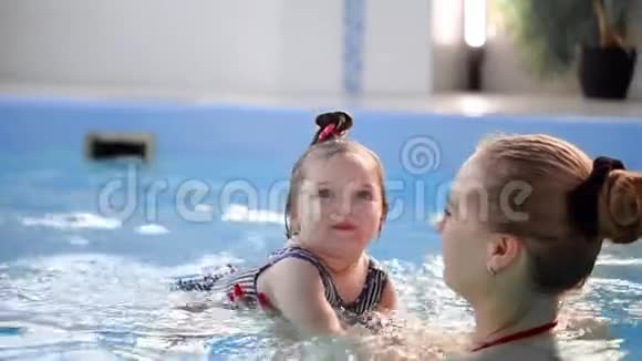 快乐微笑的幼儿在游泳池里跳着在水底下潜水一次水下射击慢动作视频的预览图